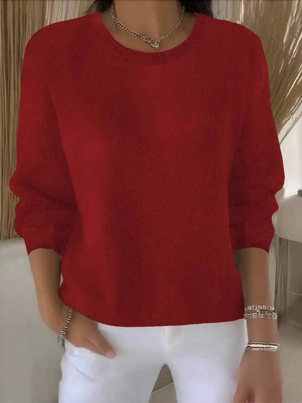 Bright red knit jumper close-up view showing ribbed crew neck and soft knit fabric