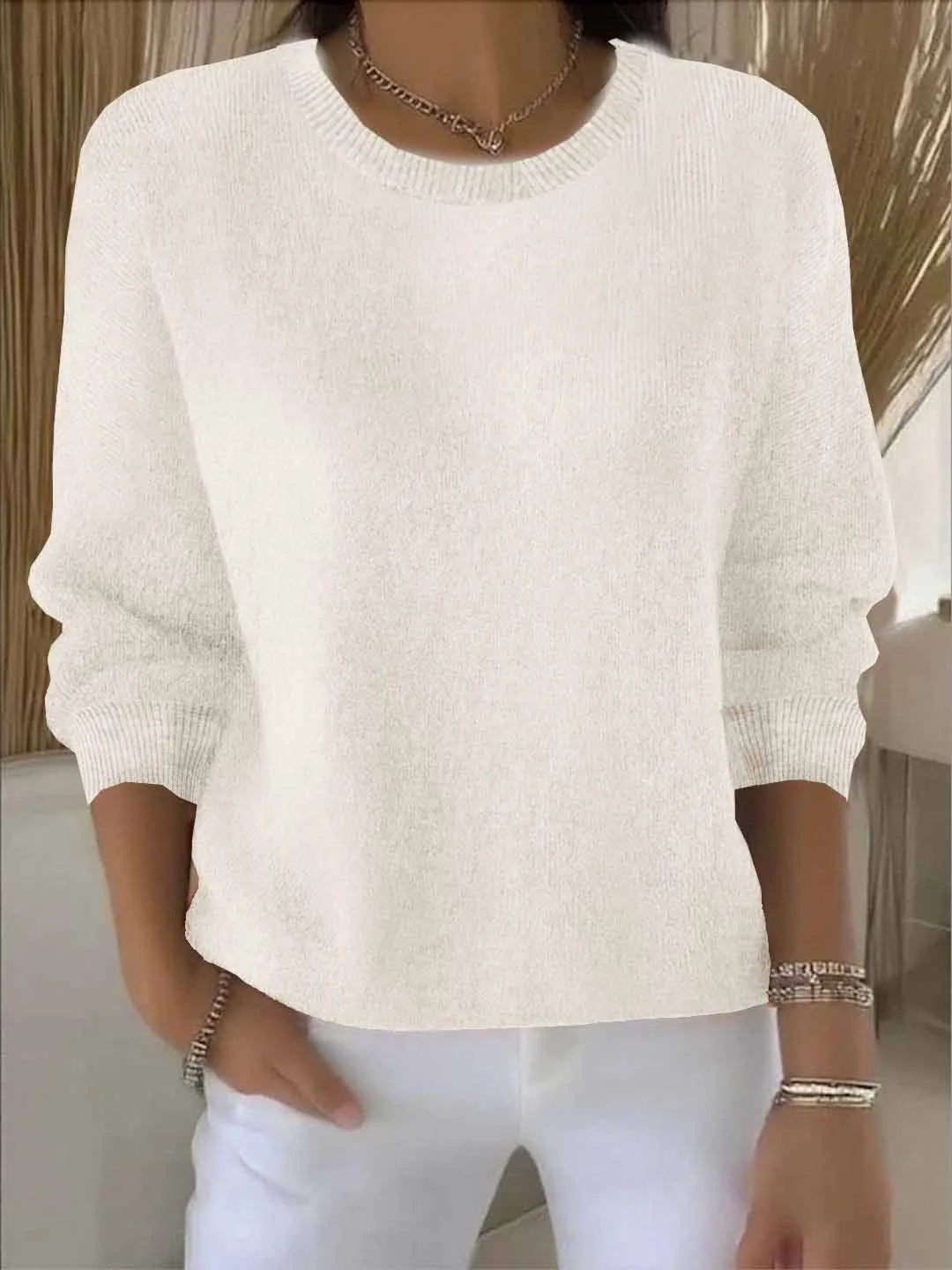 Cream knit jumper shown from the front with ribbed neckline and dropped shoulder seams