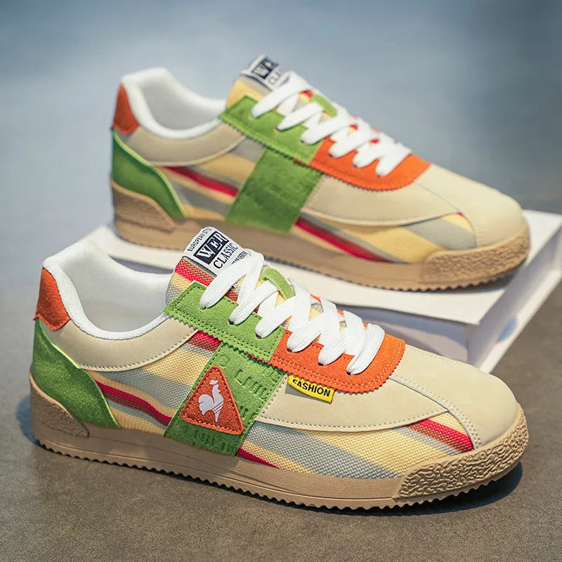 Angled view of cream, green and orange trainer resting against its shoebox