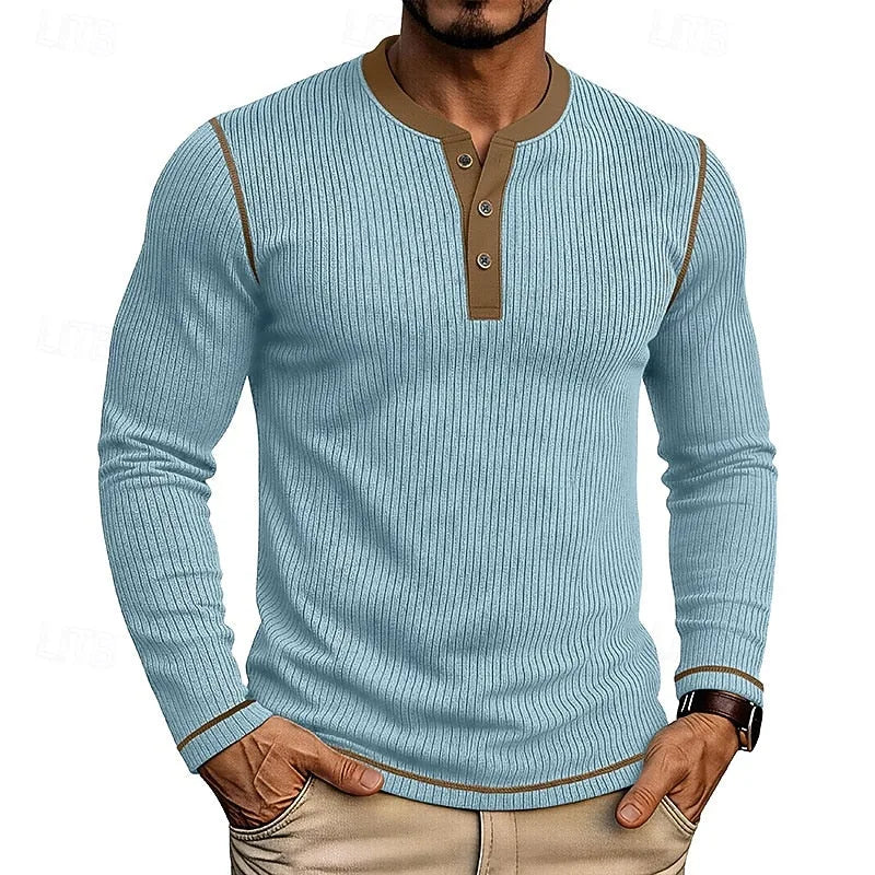 Man wearing a light blue ribbed henley jumper with brown contrast trim and button placket, front view