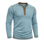 Close front shot of the light blue ribbed henley on a model, hands in trouser pockets