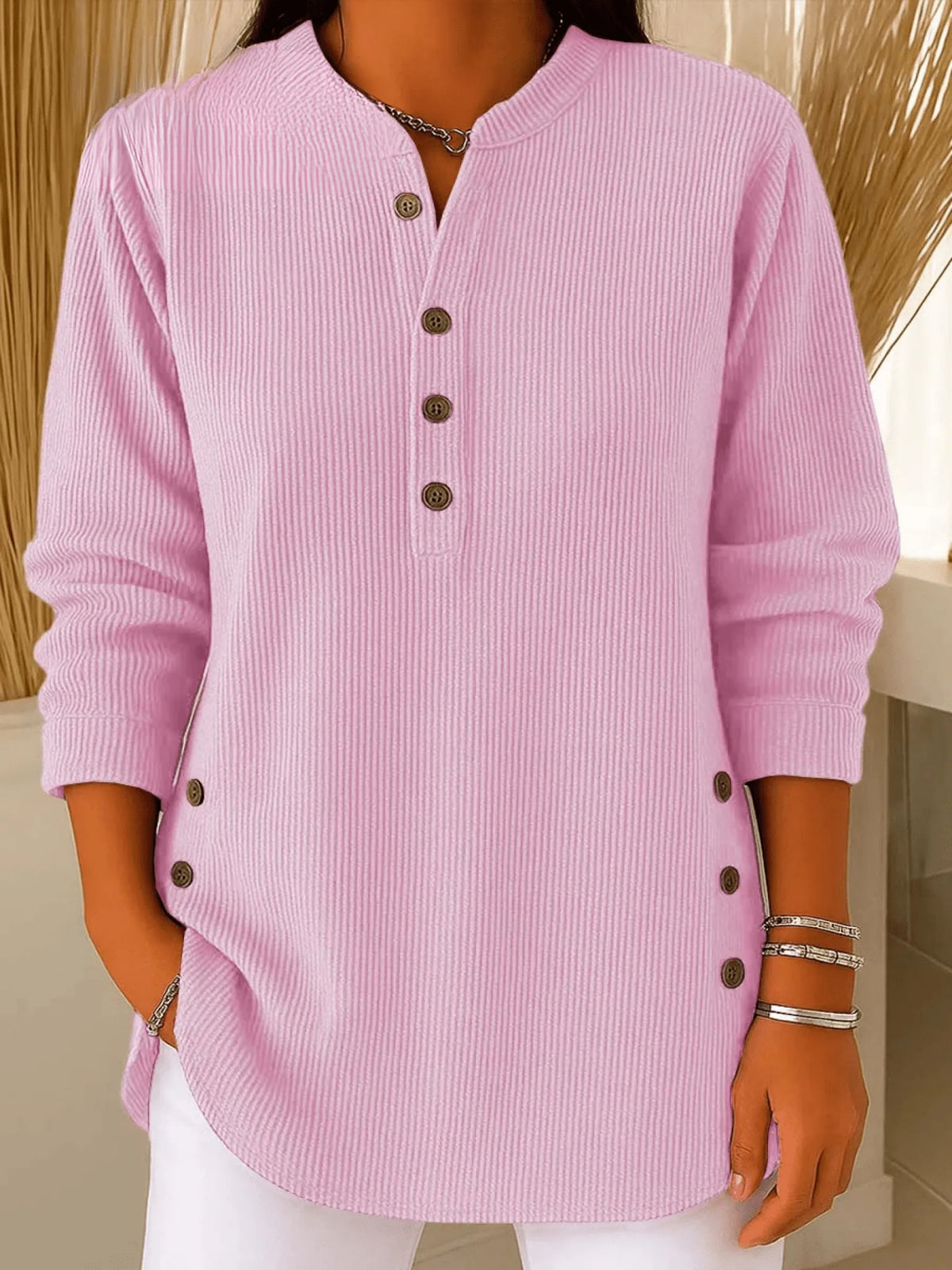 Soft pink ribbed tunic top worn with white trousers, showing the relaxed longline fit