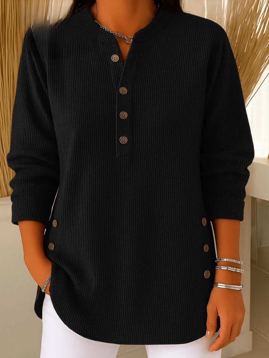 Black ribbed tunic top with Henley neckline, showing the fine vertical rib texture up close