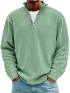 Sage green ribbed quarter-zip jumper with open collar, worn casually with light wash jeans
