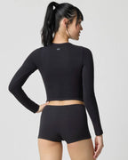 Back view of model wearing the black ribbed crop top and shorts, showing fitted raglan-style sleeve seams