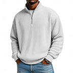 Model with hands in jeans pockets wearing the sky blue ribbed quarter-zip pullover, front angle