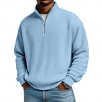 Detail shot of the ribbed fabric texture and metal zip pull on the quarter-zip collar