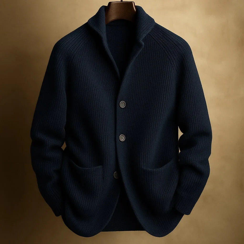 Navy blue ribbed wool cardigan buttoned up, shown on a hanger with a soft tan background