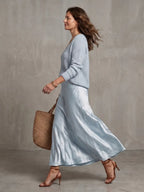 Close-up detail of the satin bias-cut skirt fabric showing its soft sheen and clean fall