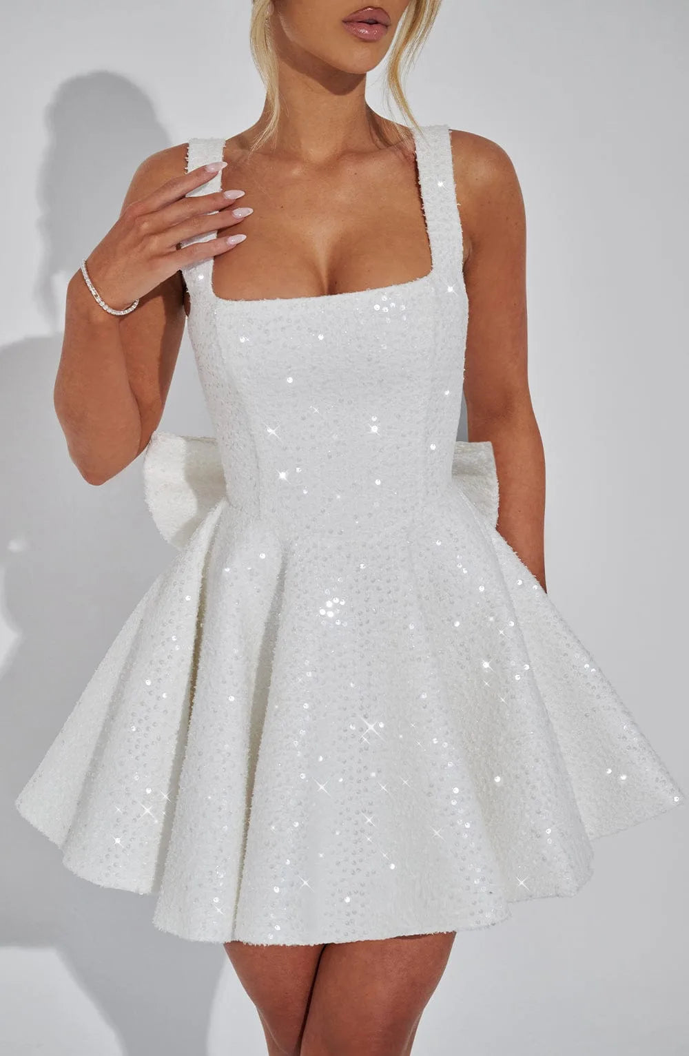 Close-up of the ivory sequinned bodice with square neckline, wide straps and textured bouclé-style fabric