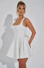 Side profile of the ivory sequin mini dress showing the fitted bodice, flared skirt and side bow detail