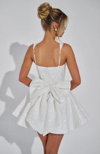 Three-quarter view of the ivory sequin mini dress highlighting the square neckline and voluminous pleated skirt