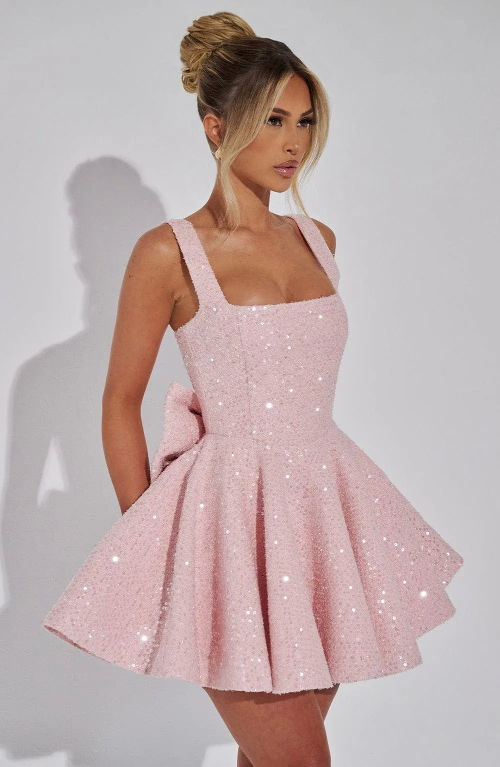 Close-up back view of the ivory dress showing the adjustable straps, hidden zip and oversized bow above the skirt