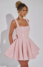 Close-up back view of the ivory dress showing the adjustable straps, hidden zip and oversized bow above the skirt