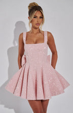 Front view close-up of the blush pink sequinned bodice and skirt with a woman's hand resting near the neckline