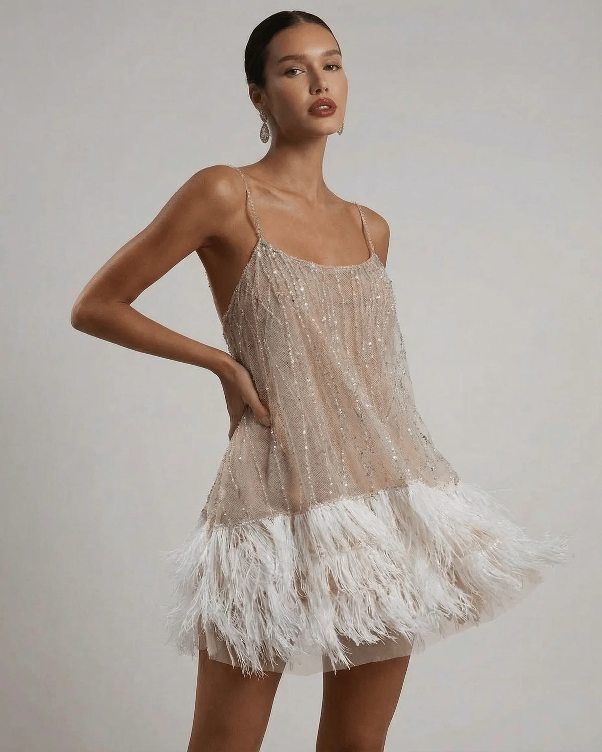 Close front view highlighting sequin embellishment across the bodice and layered feather skirt detail
