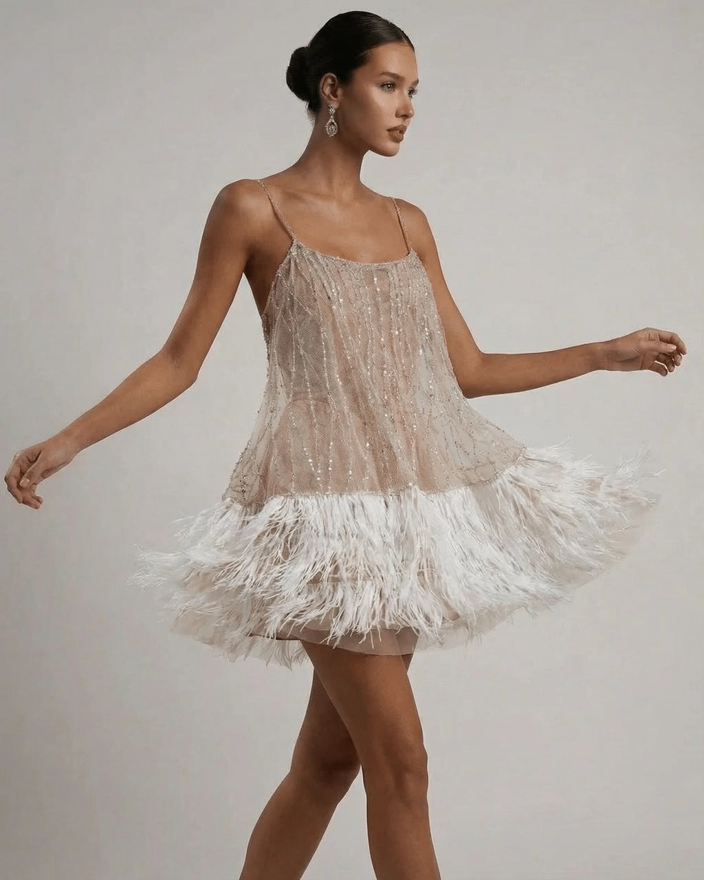 Model walking in the sequin mini dress, feather hem swishing to show movement and volume