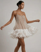 Model walking in the sequin mini dress, feather hem swishing to show movement and volume