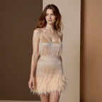 Front view of a nude beige sequin fringe mini dress with a feathered hem, paired with a v-neckline and thin straps