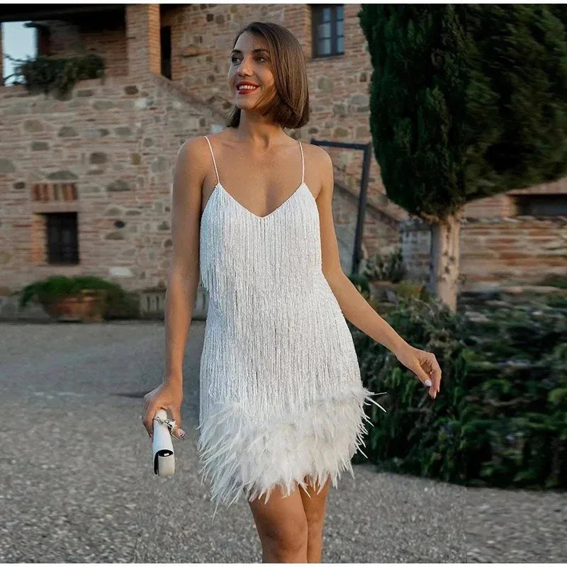 Close-up front view of the white sequin fringe mini dress showing the feathered hem and spaghetti straps