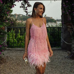 Close-up of the sequin fringe fabric texture showing the beaded strands and feather trim detail
