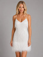 Front view of a white sequin fringe mini dress with V-neckline, thin straps and feather hem on a model