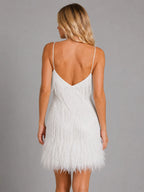 Back view of the white fringe mini dress showing a low back and cascading sequin strands to the feather trim