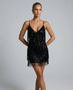 Front view of a woman in a black sequin fringe mini dress with a plunging V-neckline and thin straps