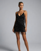 Side angle of the black sequin fringe mini dress showing movement in the tiered fringe layers