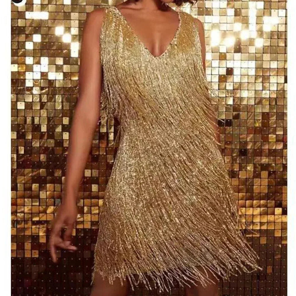Gold sequin fringe mini dress shown against a mirrored gold tile backdrop, showcasing the sleeveless V-neck cut