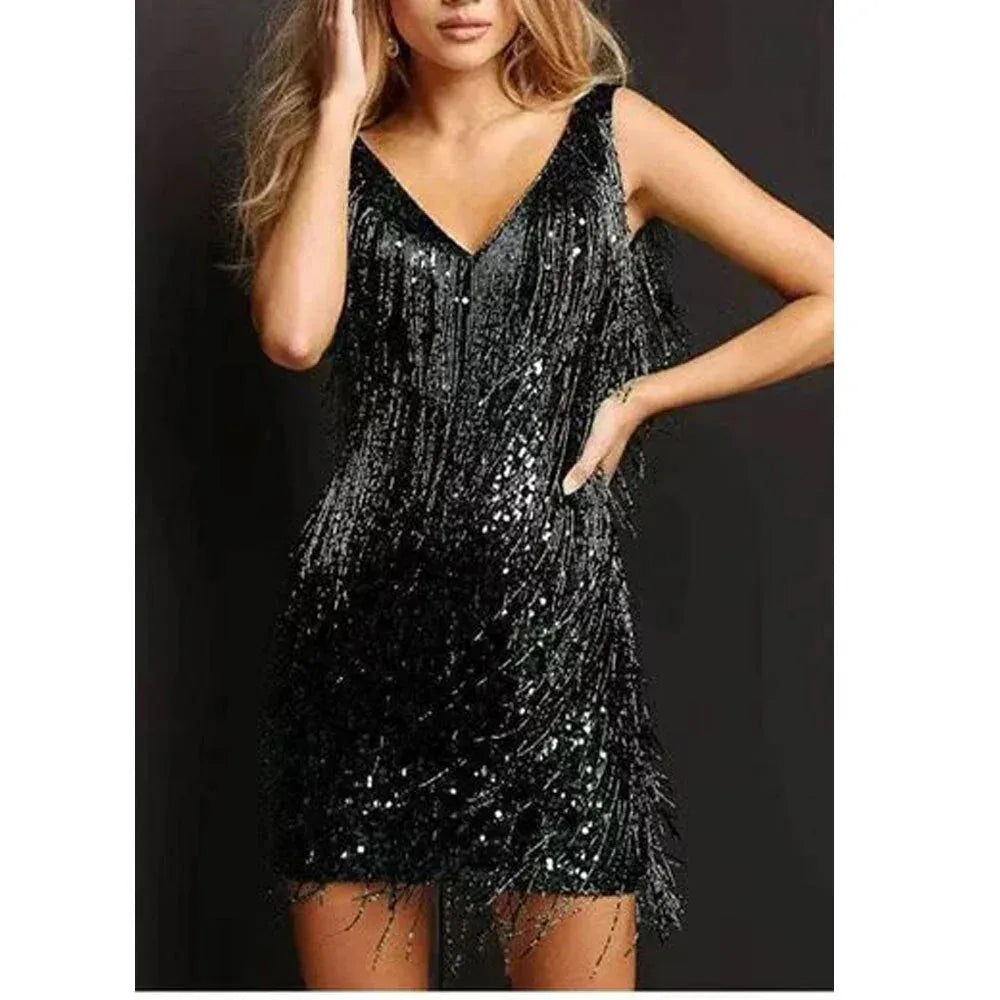 Black sequin fringe mini dress with V-neckline and cascading tassel fringe, styled with a hand resting on the hip