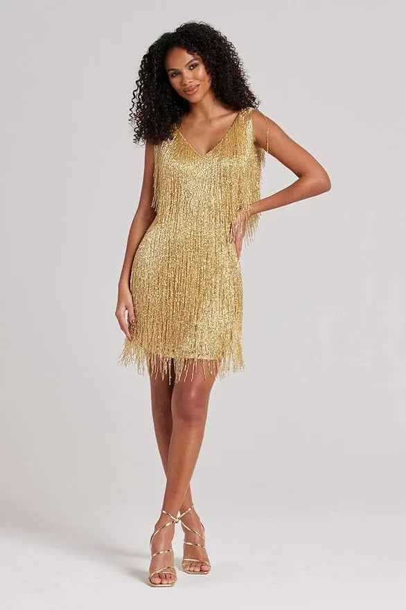 Side-angle view showing the fringe movement and shimmer of the gold sequin mini dress
