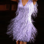 Close-up detail of a lilac/purple sequin fringe mini dress showing the cascading fringe under dramatic lighting