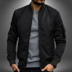 Black slim-fit bomber jacket with ribbed cuffs and hem, front zipper open, shown from the chest up