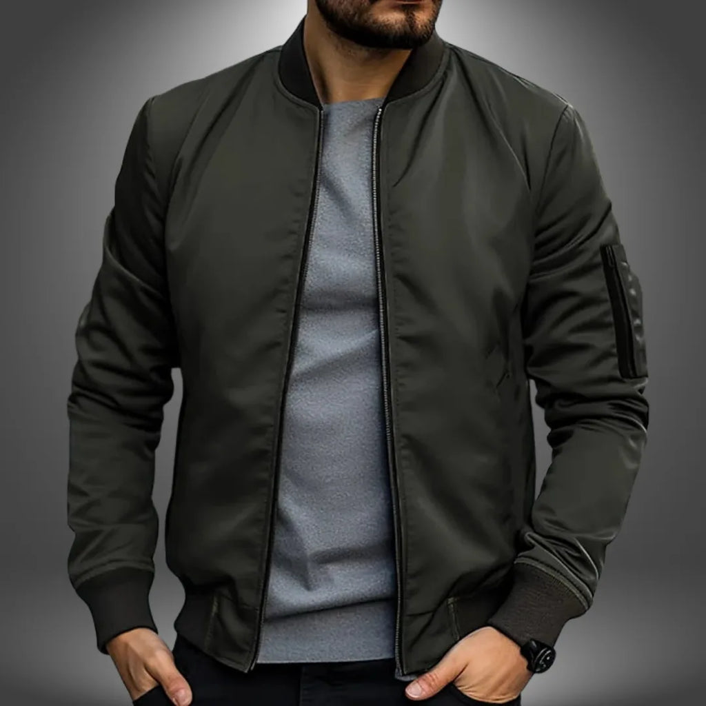 Olive-green slim fit jacket with stand collar and ribbed trims, worn unzipped over a grey jumper