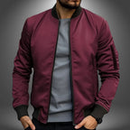 Burgundy red bomber jacket with zip sleeve pocket and ribbed collar, front open, close-up chest view