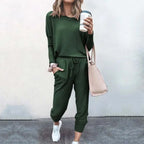 Woman in a dark green oversized top and tapered jogger set carrying a pink tote bag