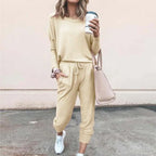 Woman wearing a pale yellow loungewear set with relaxed top and drawstring joggers, paired with white trainers