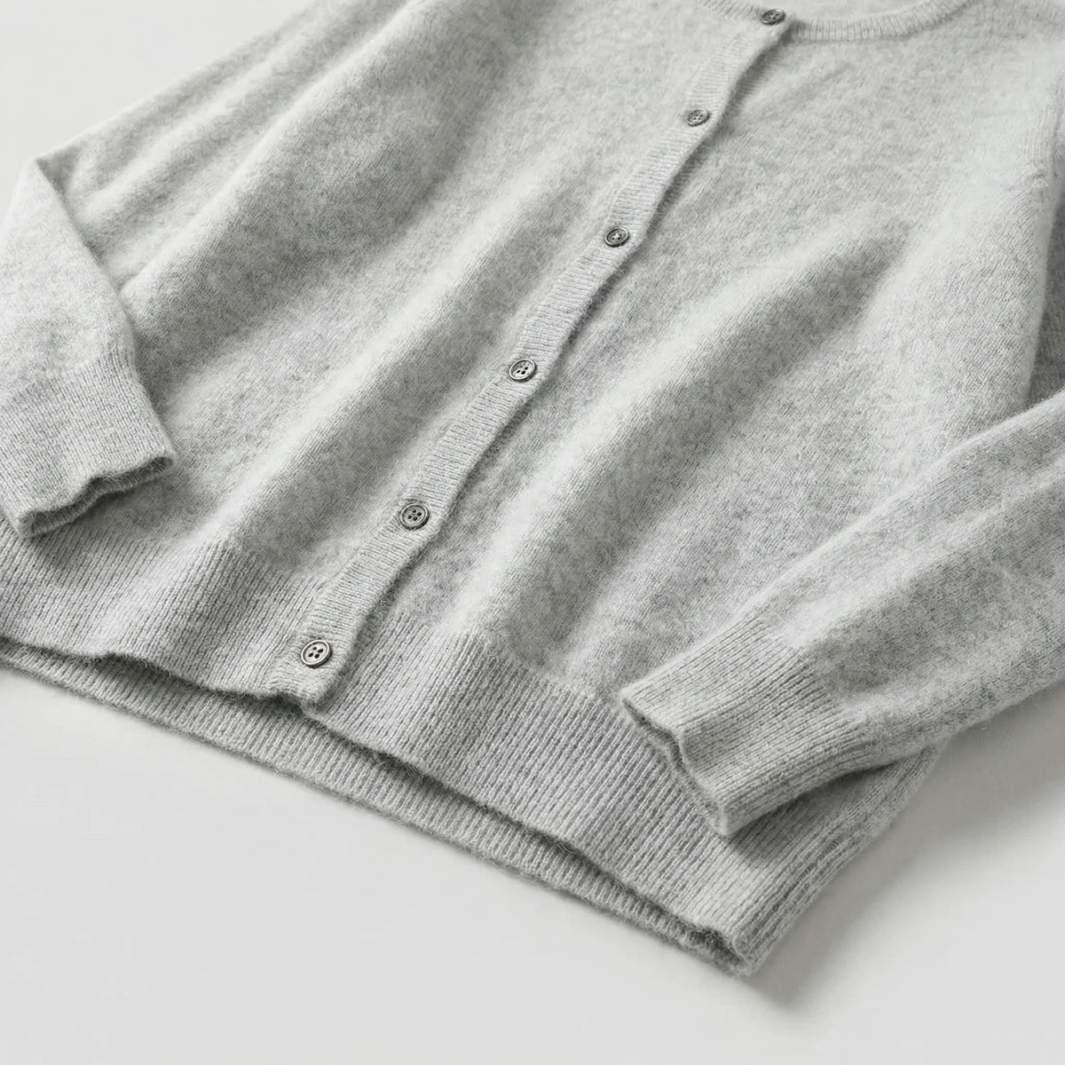 Navy blue cardigan displayed flat showing overall silhouette with crew neck and six-button closure
