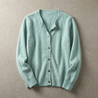 Mint green cardigan laid flat with crew neck, button placket and ribbed hem on a neutral backdrop