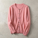 Close-up of light grey cardigan showing soft knit weave and dark button detail along the placket