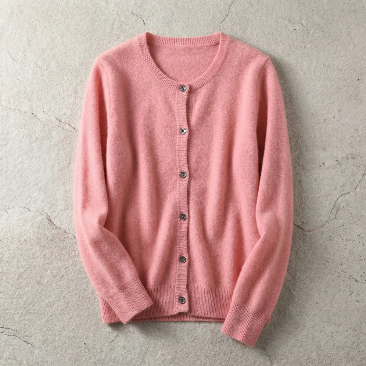 Close-up of light grey cardigan showing soft knit weave and dark button detail along the placket