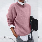 Pink mock neck jumper with a relaxed, slouchy fit, paired with grey trousers and a black backpack.