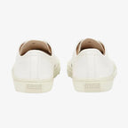 Detail shot of white split-toe trainer sole showing the ribbed tread and cream canvas panel stitching