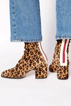 Back and side view of red suede block-heel ankle boots paired with cropped denim jeans