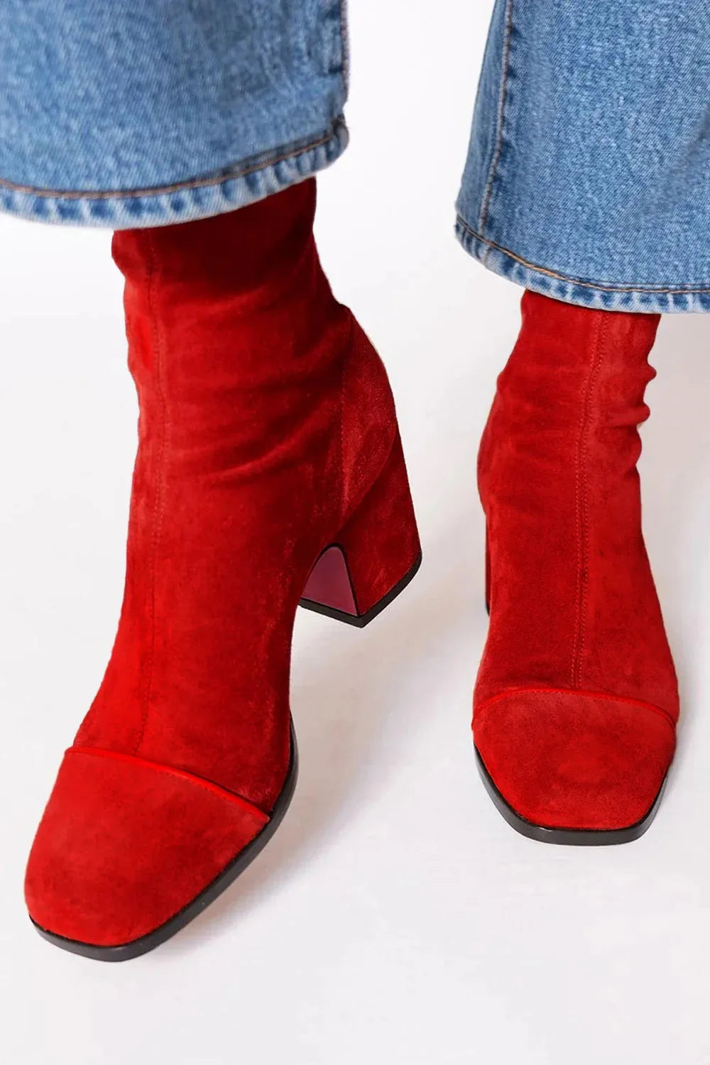 Close-up front view of red suede square-toe ankle boots with block heel and contrast piping
