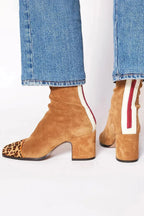 Side and back view of camel suede ankle boot with leopard-print toe cap and striped heel panel