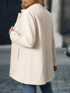 Back view of the cream coat showing the stand collar, shoulder seams and relaxed drape