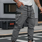 Grey cargo trousers shown from behind, highlighting the tapered leg and zippered cargo pocket