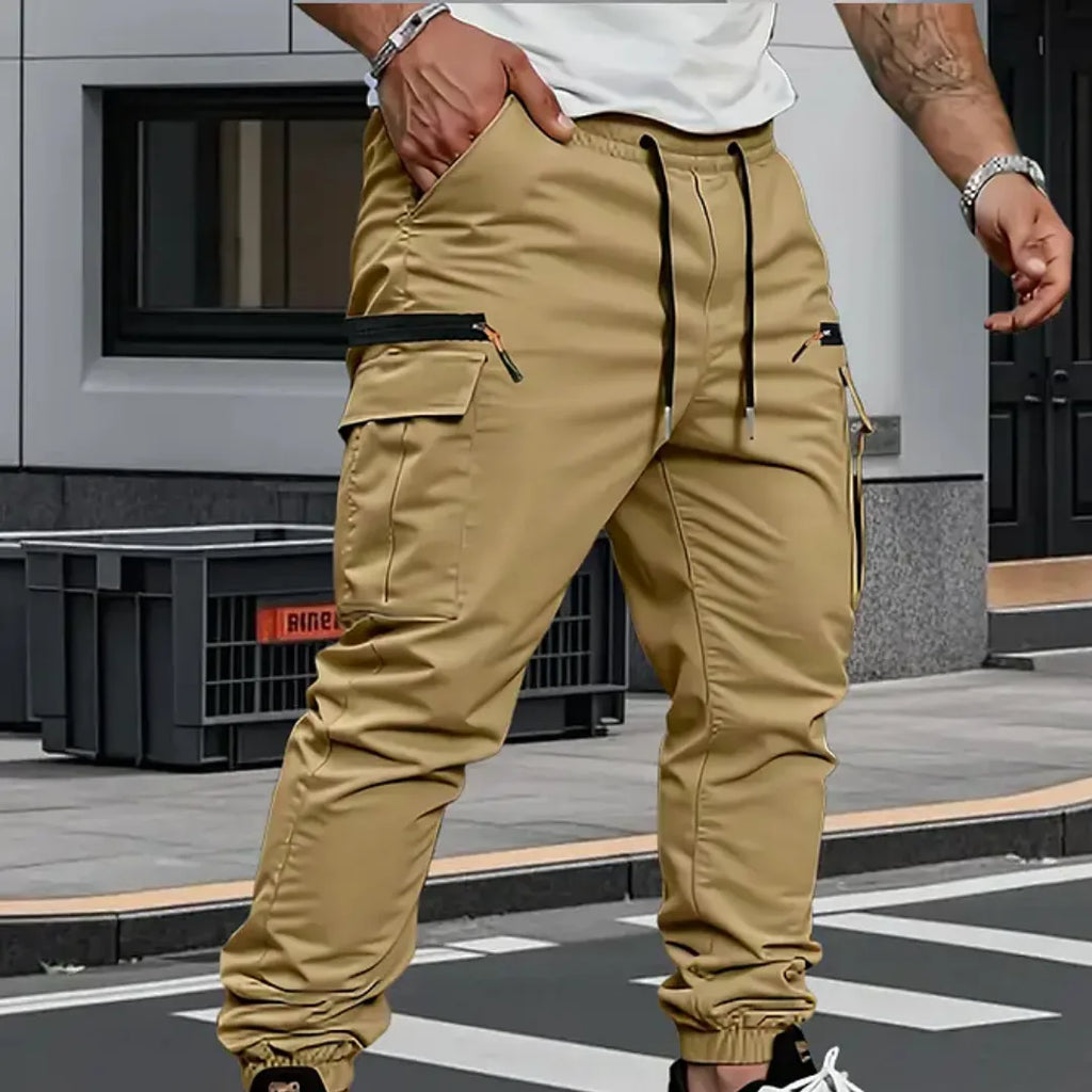 Khaki cargo trousers with visible stitching detail, drawstring waist and zip pocket on the thigh